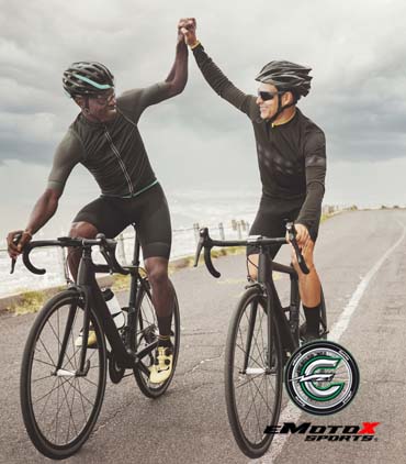 Two road cyclists high-fiving while riding, representing eMotoX Sports cycling service and rider support. | eMotoX Sports