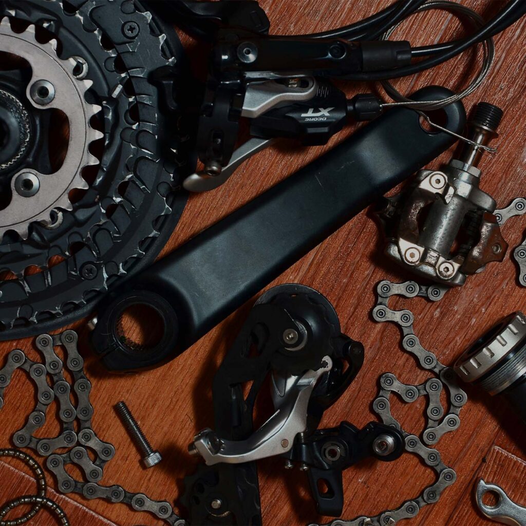 Bicycle drivetrain components including chain, crankset, derailleur, and cassette laid out for inspection and servicing - eMotoX Sports