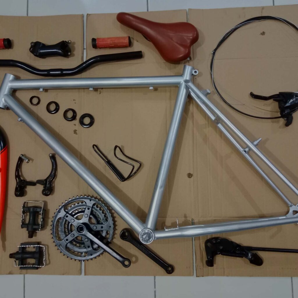 Bicycle frame fully stripped down with all components laid out for complete rebuild and inspection - eMotoX Sports