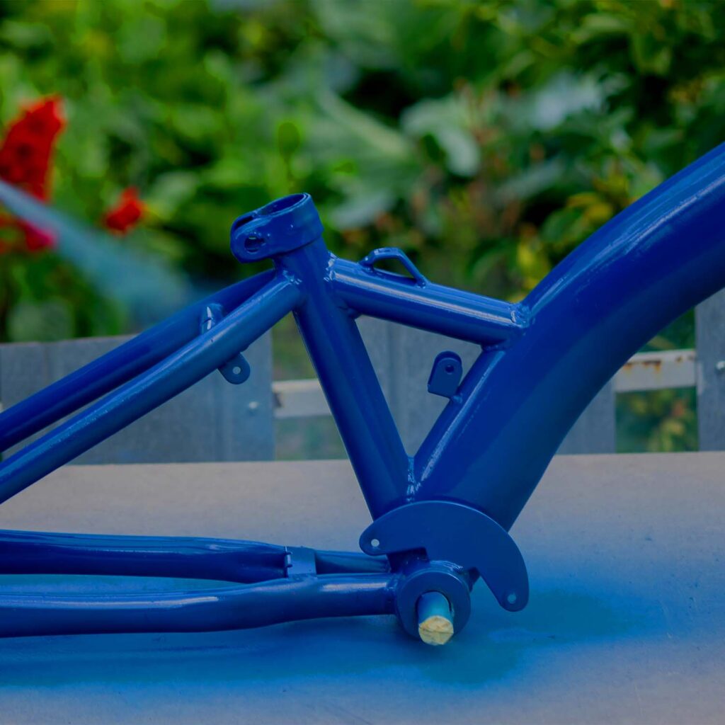 Powder-costed blue bicycle frame showing welds and frame structure detail. | eMotoX Sports
