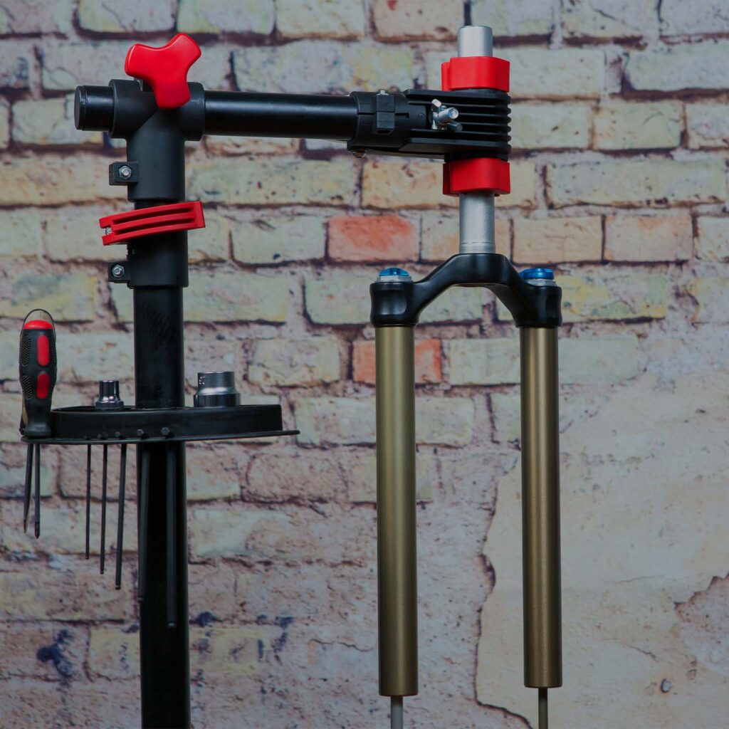 Front bicycle suspension fork being serviced on workshop stand. | eMotoX Sports