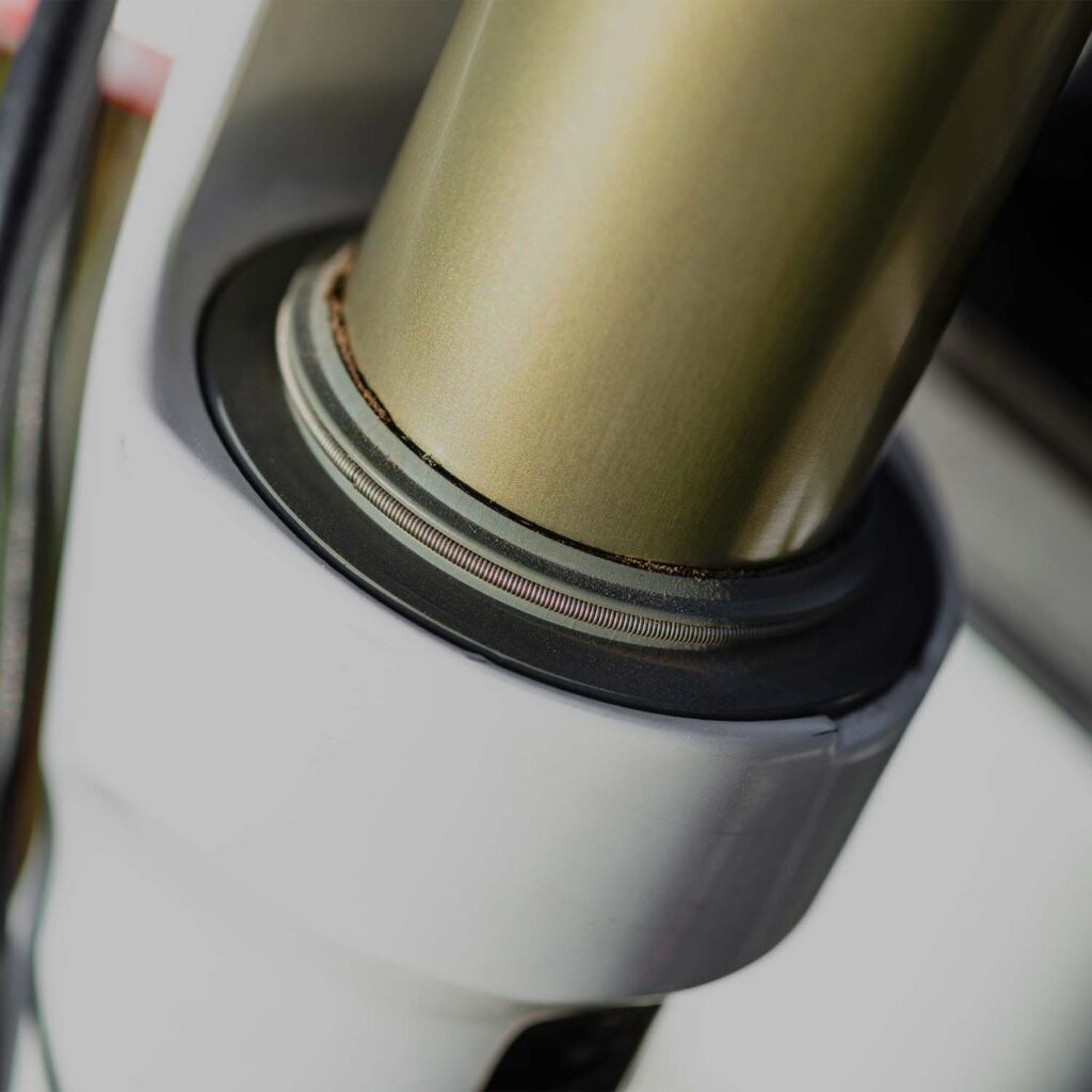 Close-up of a bicycle headset bearing and fork steerer tube fitted into the head tube, showing bearing seal and contact surfaces. | eMotoX Sports