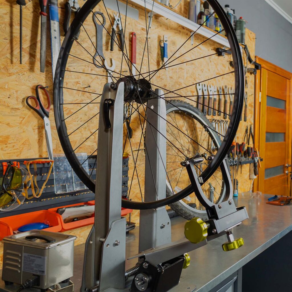 Bicycle wheel mounted in a truing stand during professional wheel alignment and spoke tensioning service. | eMotoX Sports